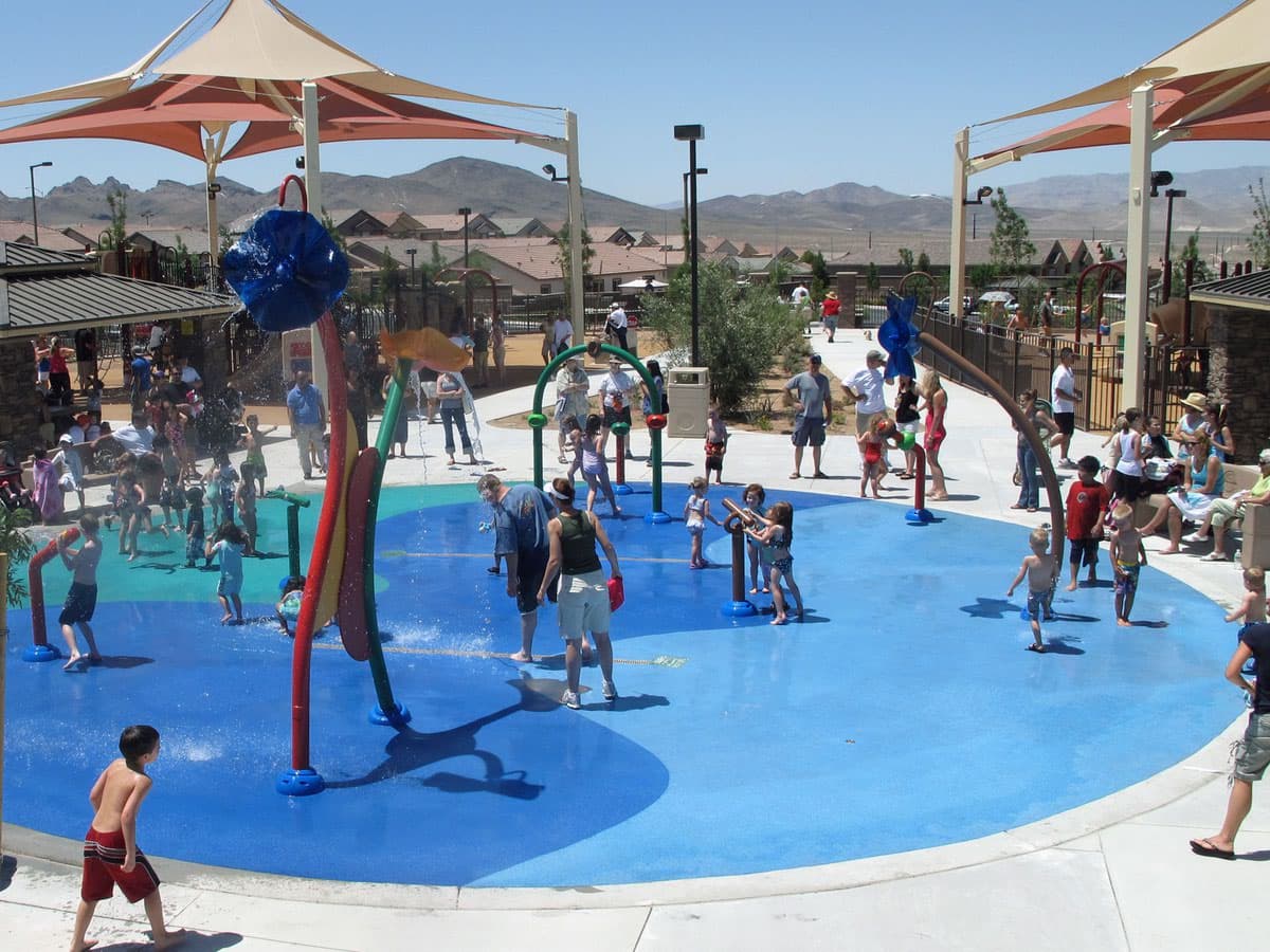 Children playing joyfully at a splash pad in a Las Vegas desert park